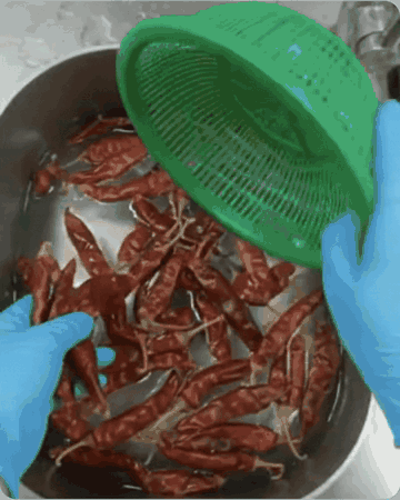 Dried chillies being rinsed in a colander before drying