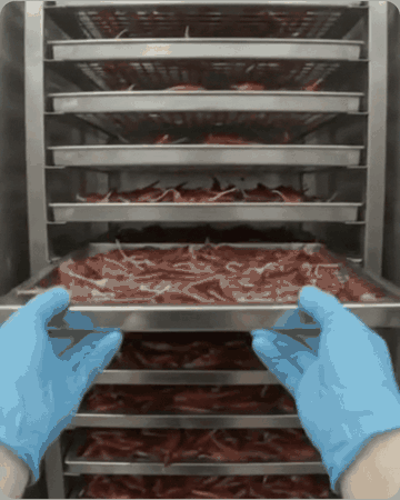 Trays of chillies being pulled out of the dryer